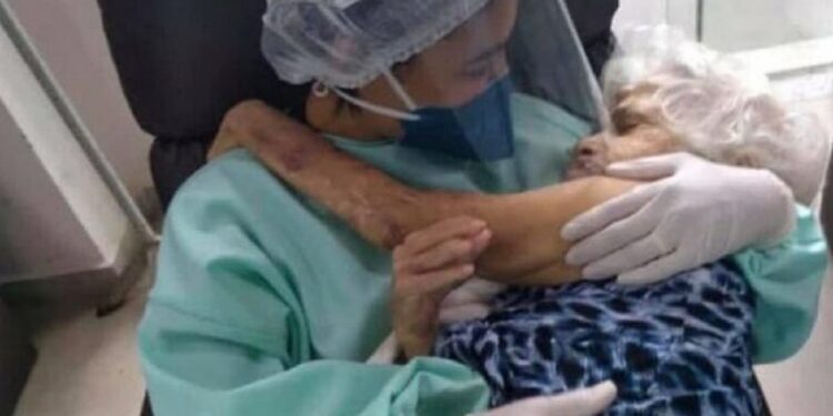 écnica de enfermagem é flagrada ninando idosa com Covid-19 e foto viraliza