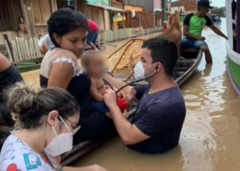 Médico e enfermeira entram na água e atendem criança no meio da enchente no Acre