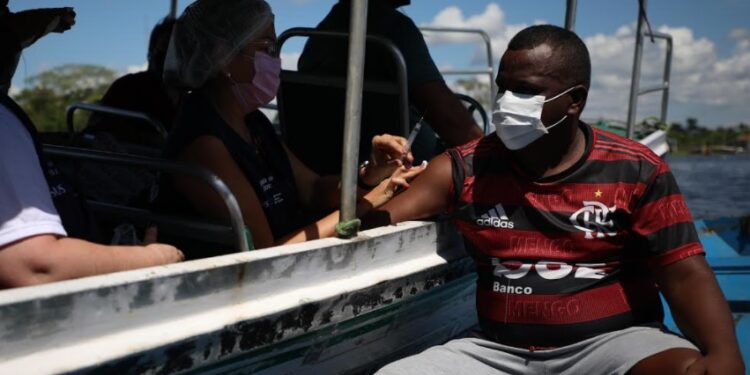 Em Iranduba, população é vacinada por drive-thru de canoa