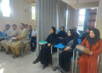 Mulheres são separadas dos homens por cortinas em sala de aula, no Afeganistão