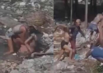 Vídeo: ‘Talarica’ é pega na porrada no meio de área alagada com lixo e pitiú