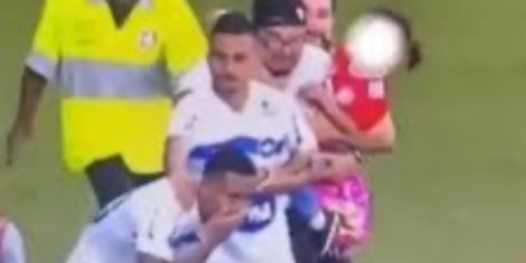 Com filha no colo, torcedor invade gramado e agride jogador