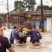 Vizinhos fazem corrente humana para ajudar pai a tirar gêmeos de casa alagada