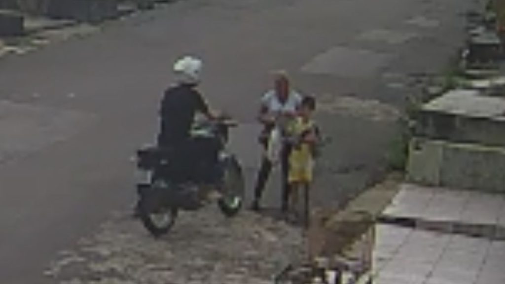 Câmera flagra assaltante de moto levando a bolsa de idosa que caminhava com o neto em Manaus